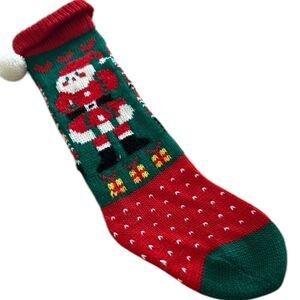 Adorable knitted long Christmas stocking with Santa and gifts.